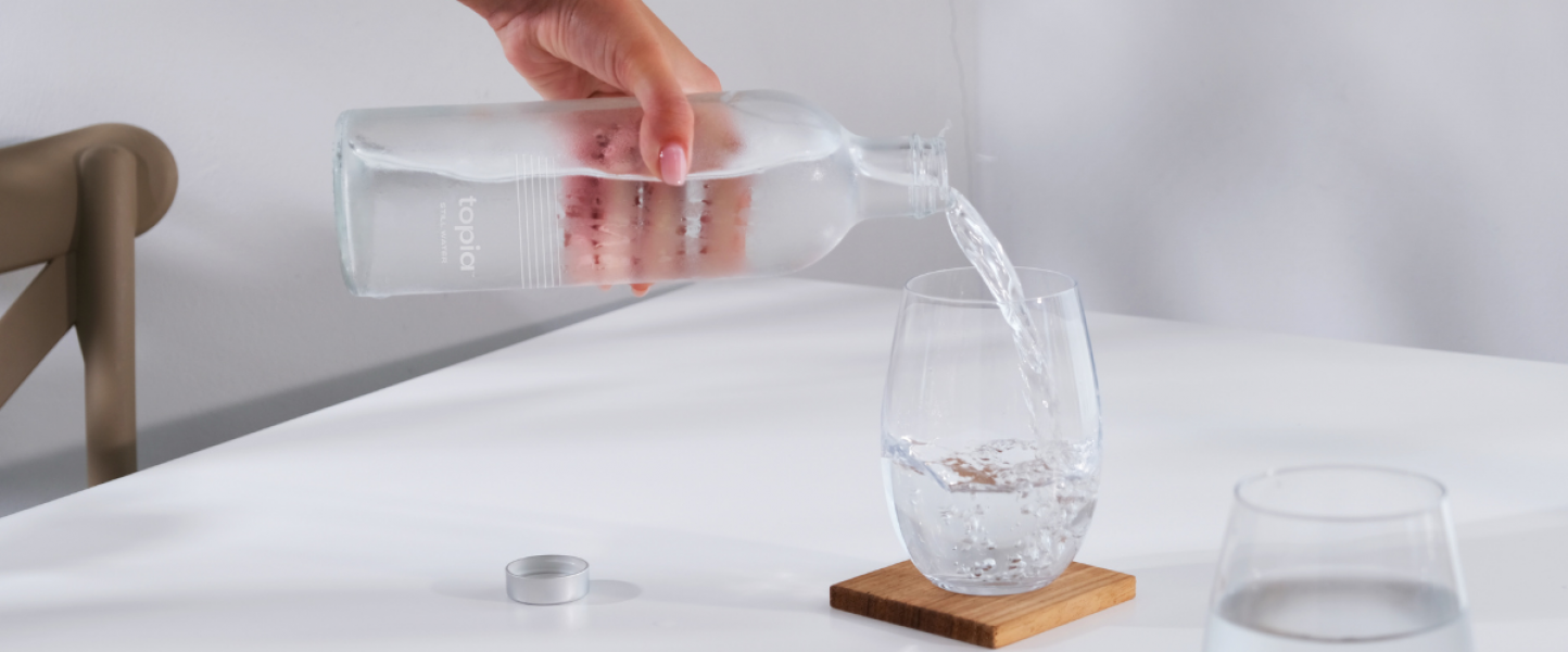 Topia Urban Twist bottle pouring water into a glass